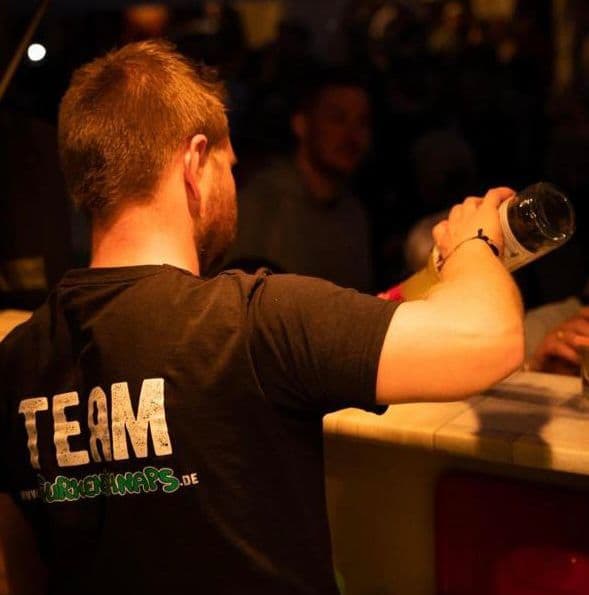 Angeklebtes Foto: Teammitglied schenkt am Gurkenschnaps-Stand im Festzelt aus
