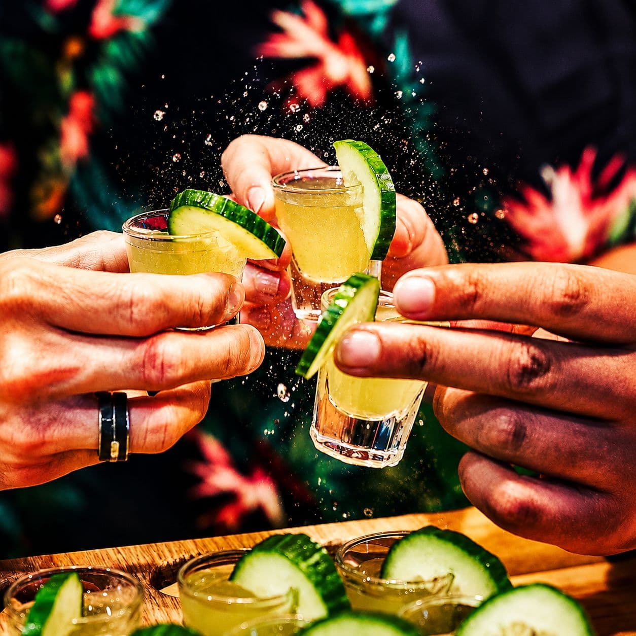 Angeklebtes Foto: Anstoßen mit Gurkenschnaps-Shots und Gurkenscheiben